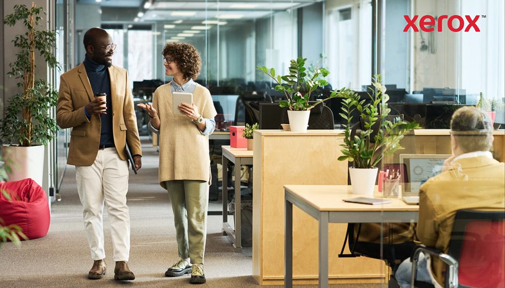 Deux professionnels marchant et discutant dans un bureau moderne